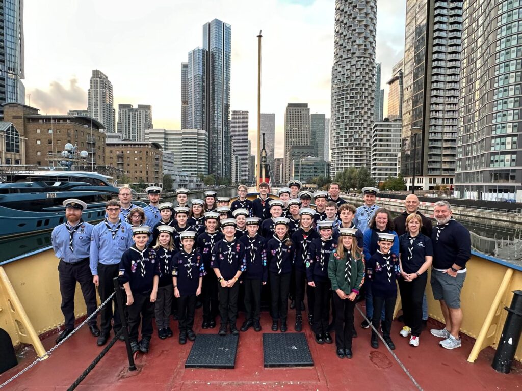 1st Sutton Coldfield Sea Scouts on bow of a boat with a city in the background